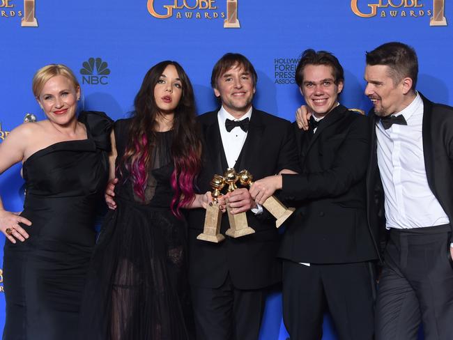 Can’t believe their luck .... Arquette poses with her Boyhood co-stars and director at the Globes yesterday.