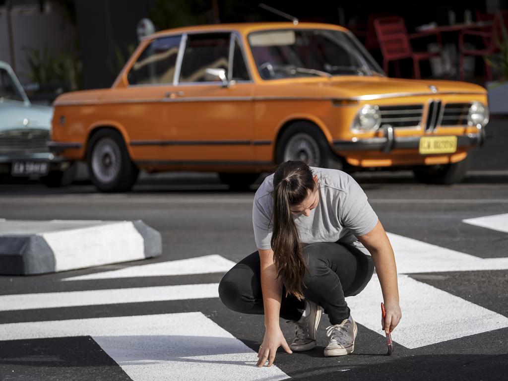 A production staff member paints a zebra crossing on to Pirie St for the movie. Picture: AAP/Mike Burton