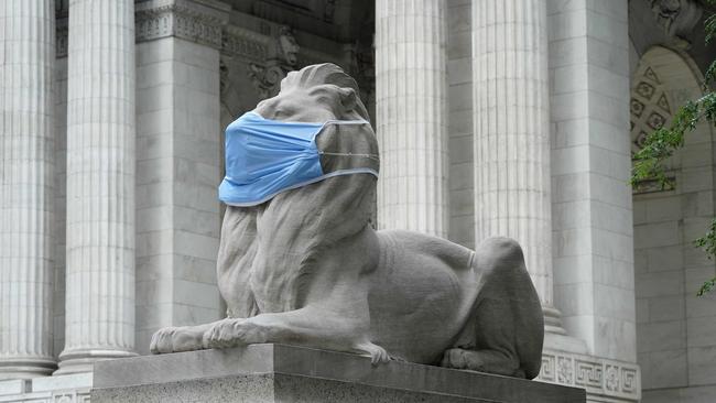 Fortitude, one of the pair of marble lions that sit in front of the New York Public Library's Fifth Avenue and 42nd Street branch on July 8, 2020 in New York, wears a face mask to encourage New Yorkers to continue to follow safety measures in the fight against COVID-19. Picture: AFP