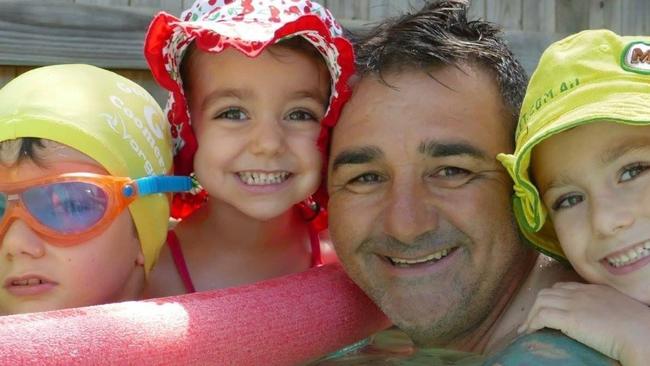 Mario Collavino swimming in the pool with his children.