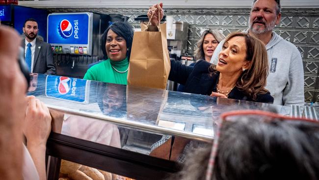 Democratic presidential nominee Kamala Harris, accompanied by Philadelphia Mayor Cherelle Parker, left, picks up an order of food. Picture: Getty Images