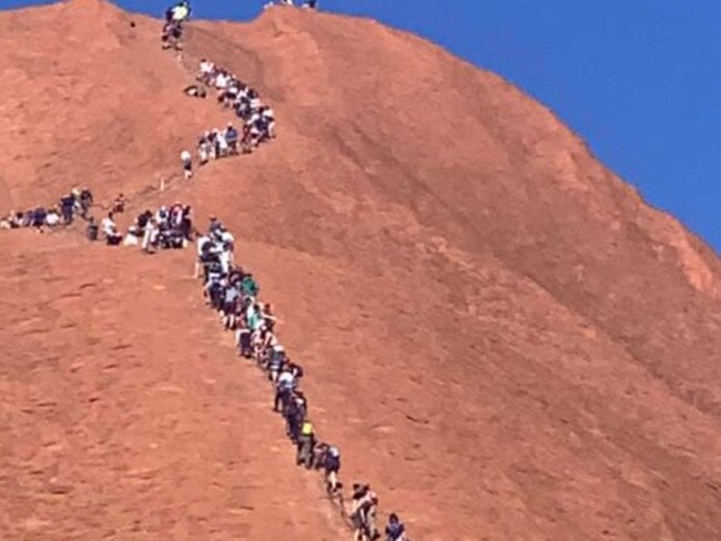 A huge line of tourists climbing up Uluru. Picture: Glenn Minett