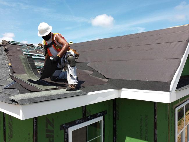 (FILES) In this file photo an aerial view is seen of a construction worker roofing an apartment home on May 27, 2020 in Uniondale, New York. - New home construction in May rose 4.3 percent compared to April, the Commerce Department said on June 17, 2020, as activity began to resume despite the coronavirus pandemic. However the pace of homebuilding hit a seasonally adjusted annual rate of 974,000, far short of what analysts had forecast, and 23.2 percent below May 2019, the report said. (Photo by AL BELLO / GETTY IMAGES NORTH AMERICA / AFP)