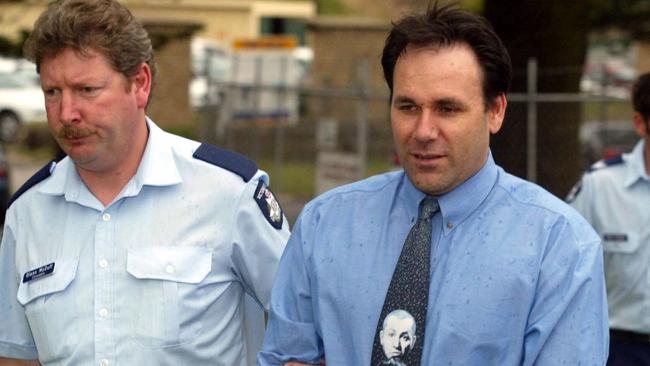 Graeme Slattery is escorted by police at the Warrnambool Court on November 12, 2002.