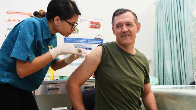 Chief Minister Michael Gunner receives his first dose of the coronavirus vaccine from nurse Nizma Tamrakar. Picture: Katrina Bridgeford.