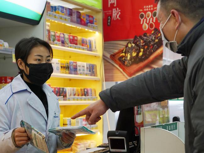 Staff sell masks at a Yifeng Pharmacy in Wuhan, Chin, Wednesday, Jan. 22, 2020. Pharmacies in Wuhan are restricting customers to buying one mask at a time amid high demand and worries over an outbreak of a new coronavirus. The number of cases of the new virus has risen over 400 in China and the death toll to 9, Chinese health authorities said Wednesday. (AP Photo/Dake Kang)