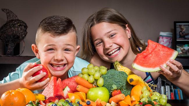 Heidi, 10, and Nate, 7, eat fruit at home. Picture: Jake Nowakowski