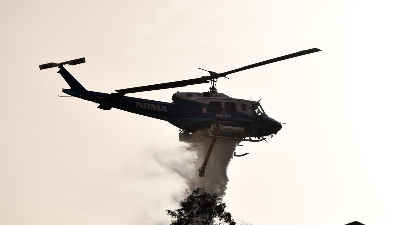 SYDNEY, AUSTRALIA - NOVEMBER 12: A NSW RFS helicopter drops water during mopping up operations at South Turramurra on November 12, 2019 in Sydney, Australia. More than 60 fires are burning across NSW with 200 homes and sheds destroyed and three people confirmed dead. Catastrophic fire danger - the highest possible level of bushfire danger - has been forecast for the greater Sydney, Illawarra and Hunter areas which includes the Blue Mountains and the Central Coast. NSW Premier Gladys Berejiklian declared a state of emergency on Monday, giving giving emergency powers to Rural Fire Service Commissioner Shane Fitzsimmons and prohibiting fires across the state. (Photo by Sam Mooy/Getty Images)