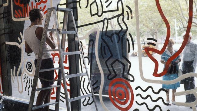 Onlookers watch as New York artist Keith Haring paints the NGV’s water wall.