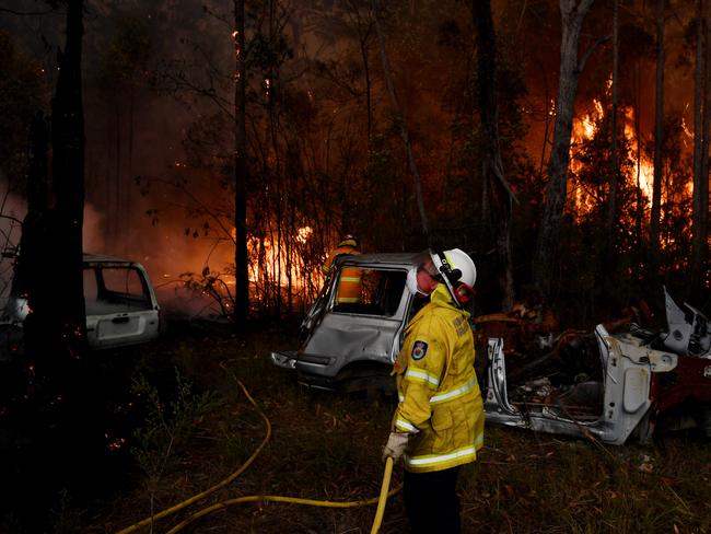 Rural Fire Service (RFS) firefighters conduct property protection near the town of Sussex Inlet on December 31, 2019 in Sydney, Australia. There are a number of dangerous bushfires burning at emergency level across NSW as weather conditions deteriorate with temperatures expected to rise ahead of gusty southerly change. Princes Highway on the NSW South Coast has been closed with motorists told to avoid all non essential travel. Volunteer firefighter Sam McPaul was killed when his truck rolled over in a freak wind event near Jingellic near the NSW-Victorian border on Monday evening. Picture: Sam Mooy/Getty