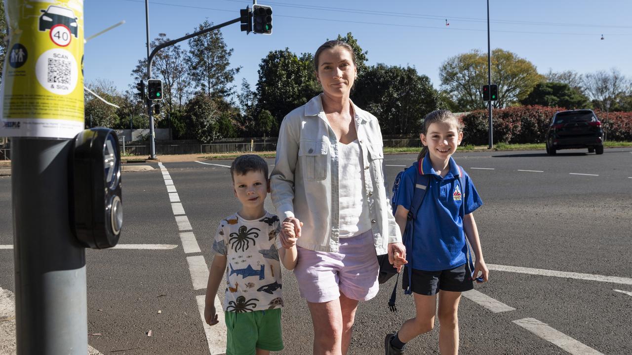 Highfields State School P and C member Sheridan Fuller crosses the road with her children Campbell and Charlotte as the P and C petition for the New England Highway speed limit to be dropped to 40km/h to create a school zone, Thursday, August 29, 2024. Picture: Kevin Farmer