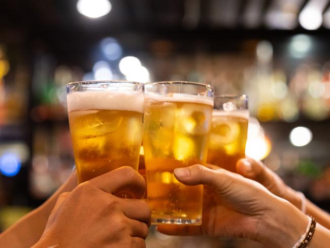 Group of happy friends drinking and toasting beer at brewery bar restaurant - Friendship concept with young people having fun together at cool vintage pub - Focus on middle pint glass