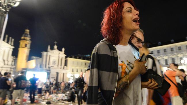 A distraught Juventus fan evacuates the Piazza San Carlo.