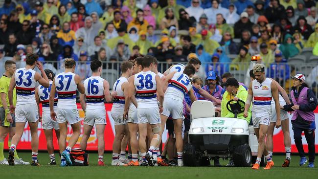 Honeychurch’s teammates get around the fallen Bulldog. Picture: Getty Images