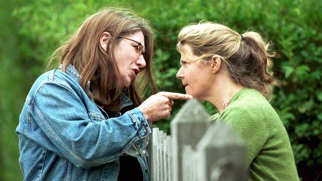## HAVE YOU /CHECKED COPYRIGHT /CLEARANCE ?? 03 Apr 2003: Two women arguing across a fence re: neighbourhood dispute. people quarrelling fences disputes neighbours generic profile pointing finger