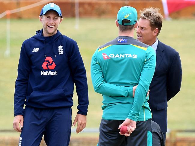 England captain Joe Root (L) laughs while Australian captain Steve Smith (C) and former Australian cricketer Shane Warne look on during a pitch inspection.