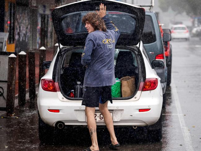 A resident packs a car of stock from a shop in the town of Lismore on March 5, 2025. A rare tropical cyclone veered towards Australia's densely populated eastern coast on March 5, forcing scores of schools to close as worried residents stripped supermarket shelves bare. (Photo by DAVID GRAY / AFP)