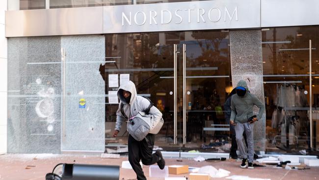 People are seen looting stores at the Grove shopping center in the Fairfax District of Los Angeles.