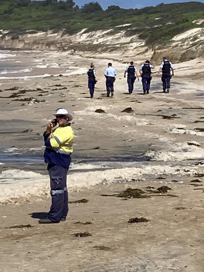 Police inspect the sand at Soldiers Beach, Norah Head.