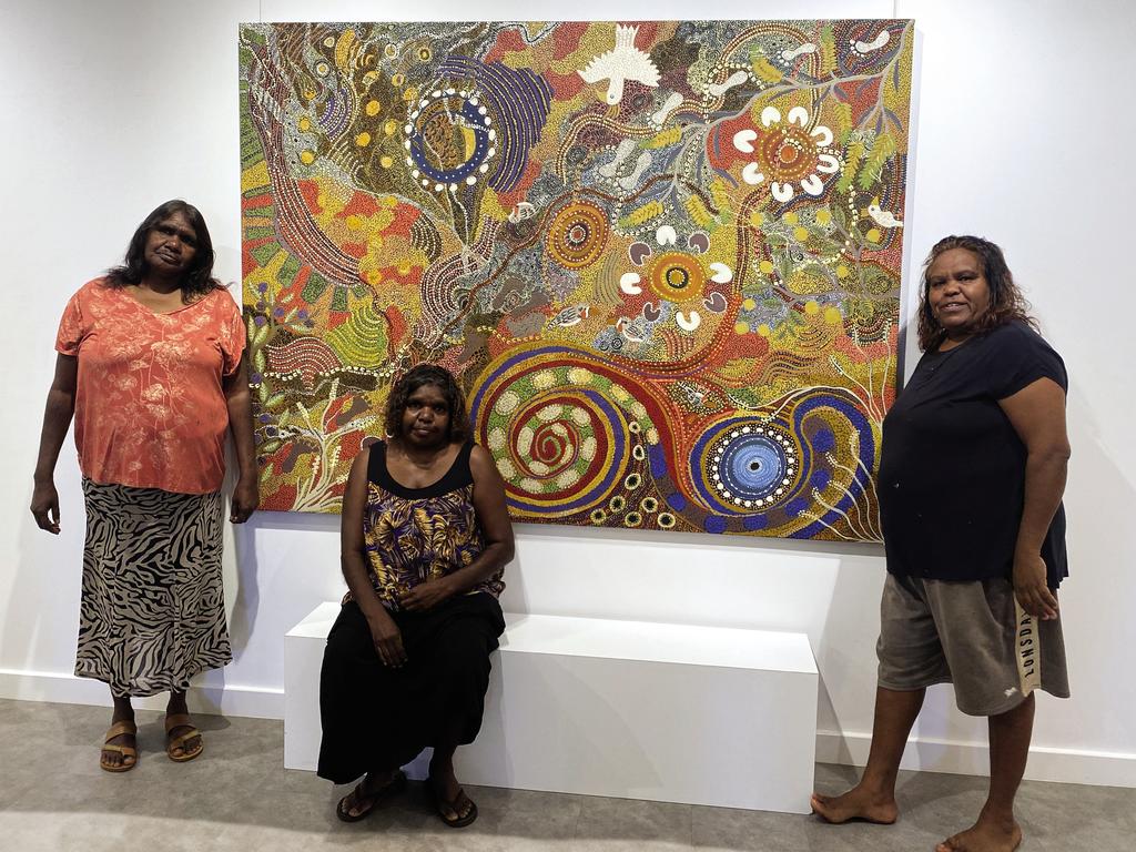 Sunrise Journeys artwork hanging at GoCA together with the three artists: L-R: Selina Kulitja (Maruku Arts), Valerie Brumby (Walkatjara Art and Denise Brady (Kaltukatjara Art)