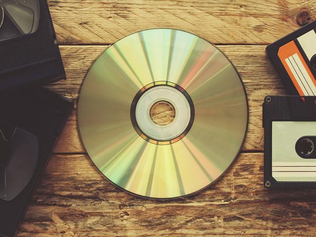 video tapes, audio tapes and compact disc on a wooden table