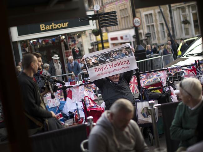 A man holds a poster of the royal weeding outside Windsor Castle as excitement builds. Picture: AP/Emilio Morenatti