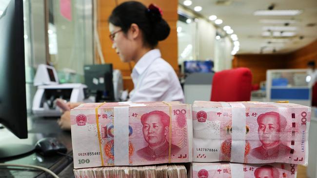 An employee counts 100-yuan notes at a bank in Nantong in China's eastern Jiangsu province on July 23, 2018.  China on July 23 rejected accusations by US President Donald Trump that it was manipulating the yuan to give its exporters an edge, saying Washington appeared "bent on provoking a trade war". / AFP PHOTO / - / China OUT