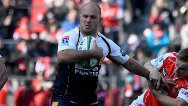 Brumbies' Lachlan McCaffrey (C) tries to fight off a tackle by Sunwolves' Hayden Parker (R) during their Super Rugby match between Japan's Sunwolves and Australia's Brumbies at the Chichibunomiya Rugby Stadium in Tokyo on February 24, 2018. / AFP PHOTO / Toru YAMANAKA