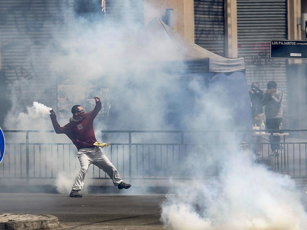 A demonstrators throws a tear gas can during clashes between protesters and the police as Chile's president declared a state of emergency. Picture: AFP