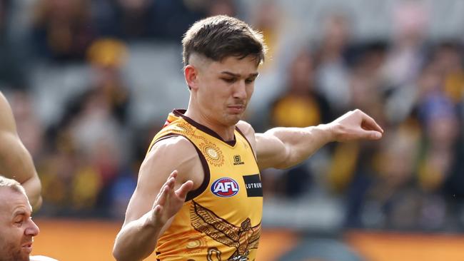 MELBOURNE - July 2  : AFL.   Sam Butler of the Hawks kicks at goal whilst being tackled by Sam Docherty of the Blues during the round 16 AFL match between Hawthorn and Carlton at the MCG on July 1, 2023.  Photo by Michael Klein.