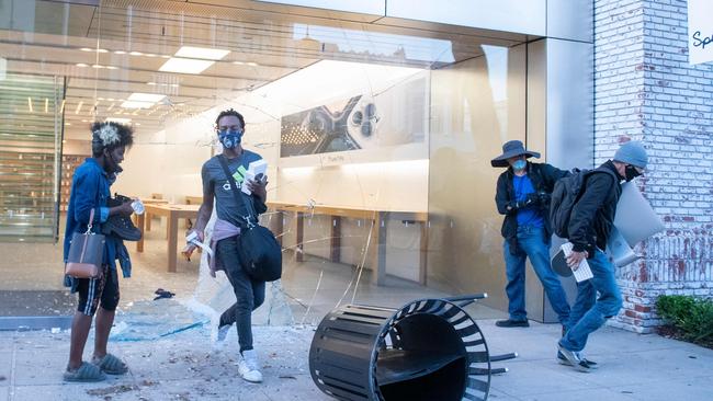 People are seen looting the Apple store at the Grove shopping centre in the Fairfax District of Los Angeles.