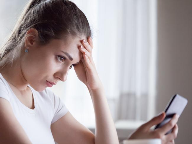 Angry young woman looking at smartphone frustrated by no signal or scam message, mad female disappointed by bad news reading on phone, upset girl get negative or rejection response on mobile; generic scam