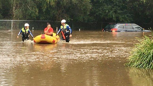 DON’T DRIVE IN FLOODWATER: A woman is rescued from her car stuck in flood water. Photo: Central Coast Volunteer Rescue Association