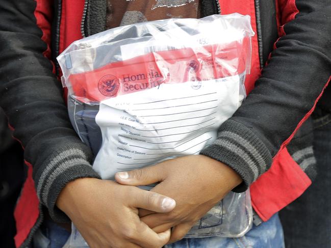 FILE - In this Friday, June 22, 2018, file photo, a young immigrant holds his belongings in a Homeland Security bag while waiting to enter the bus station after being processed and released by U.S. Customs and Border Protection, in McAllen, Texas. Foster care advocates say the government wonâ€™t likely be able to reunite thousands of children separated from parents who crossed the border illegally, and some will end up in an American foster care system that is stacked against Latinos and other minorities. (AP Photo/David J. Phillip, File)