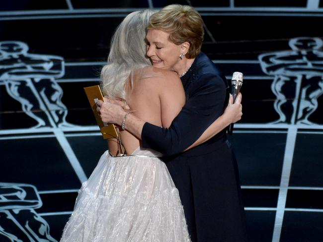 Lady Gaga and Julie Andrews embrace on the Oscars stage.