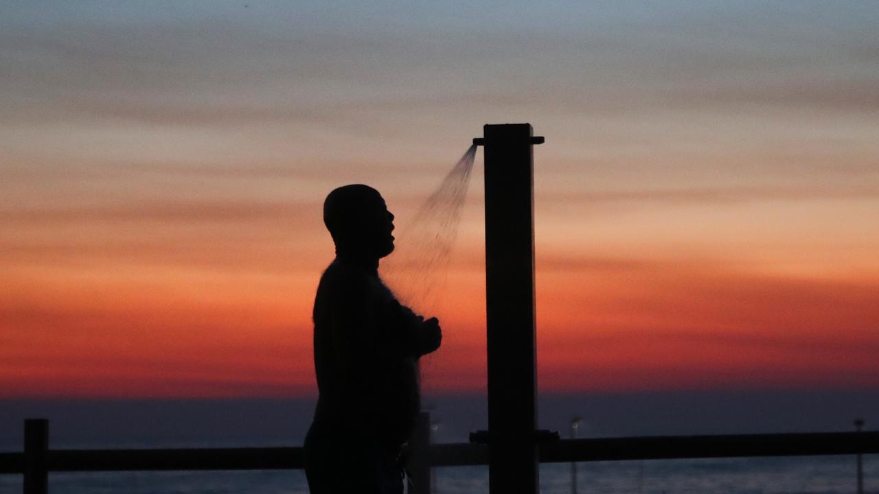 A smokey sunrise at Sydney’s Mona Vale beach. Picture: John Grainger