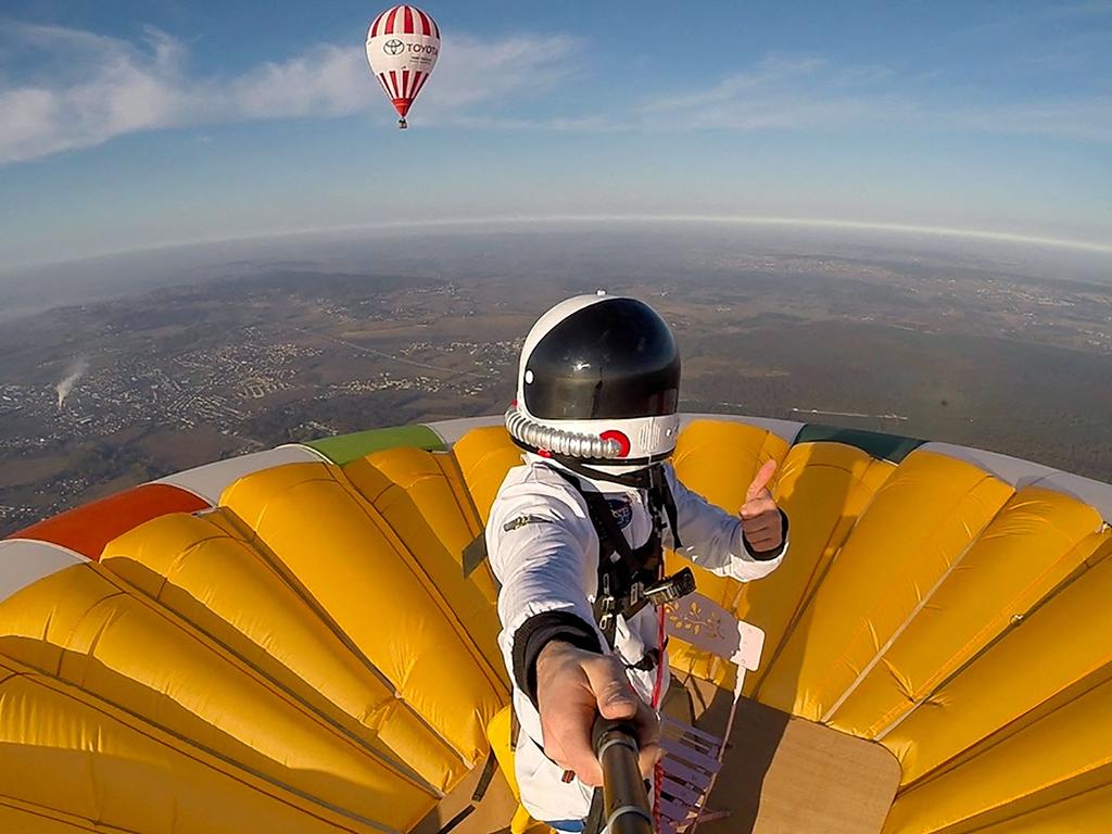 This selfie picture taken on November 10, 2021, shows French balloonist Remi Ouvrard attempting to set a world record by standing on the top of a hot air balloon for the Telethon at an altitude of over 3637 meters, in Chatellerault, western France. (Photo by REMI OUVRARD / AFP)