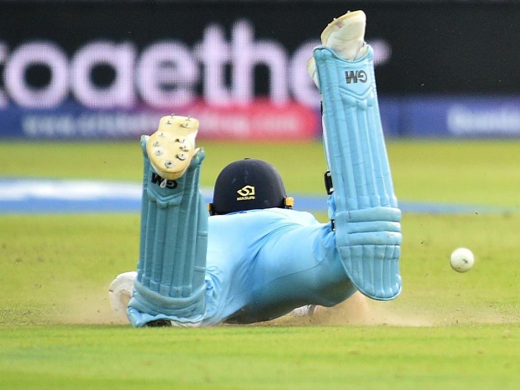 The ball hits England's Ben Stokes, deflecting to reach the boundary as he dives to make his ground. (Photo by Glyn KIRK / AFP)