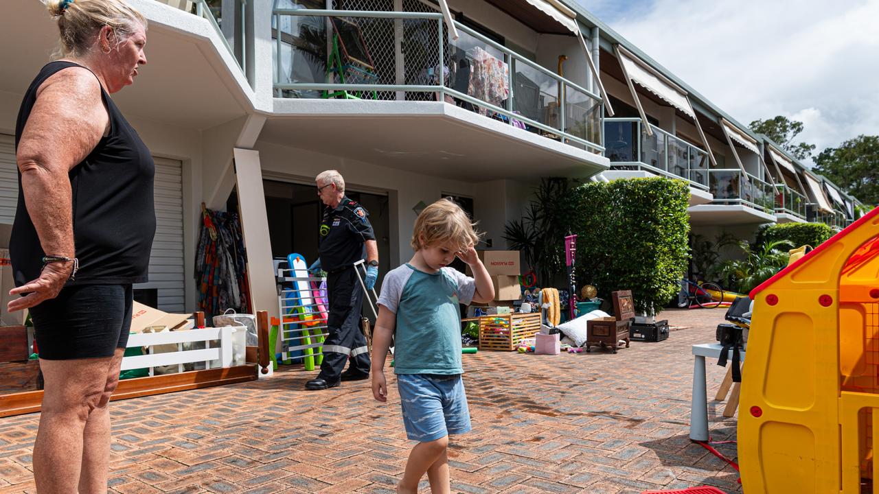 Nana Tracey Bell watches grandson William Hoskinson in the aftermath of the floods. Photo Paul Beutel