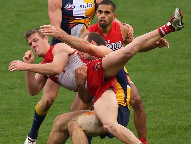 Luke Parker of the Swans gets his handball away while being tackled by the Eagles’ Shannon Hurn. Picture: Paul Kane