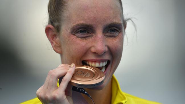 Australia’s Kareena Lee bites her bronze medal at a ceremony after the women's 10km marathon swimming. Picture: AFP