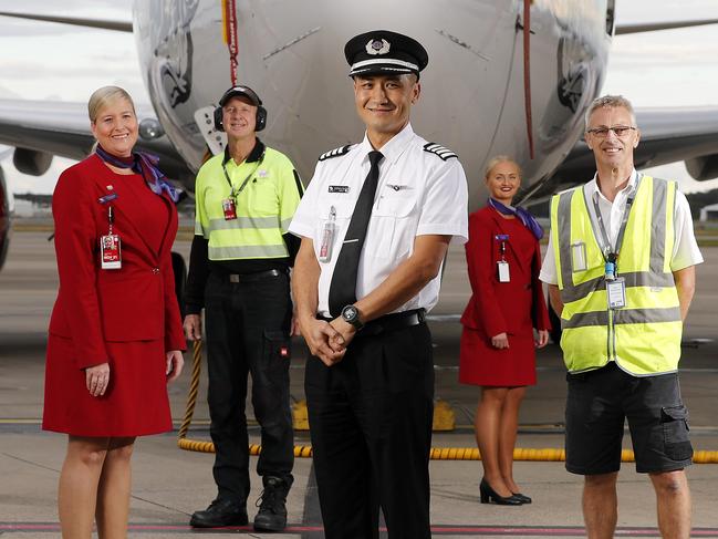 Virgin staff Chelsea Dodd, Phil Vlieg, Captain Anthony Saville, Kelby Buchanan and Peter Armstrong posing in front of Long Beach, 737-800 at the Brisbane Domestic Airport, Brisbane 14th of May 2020.