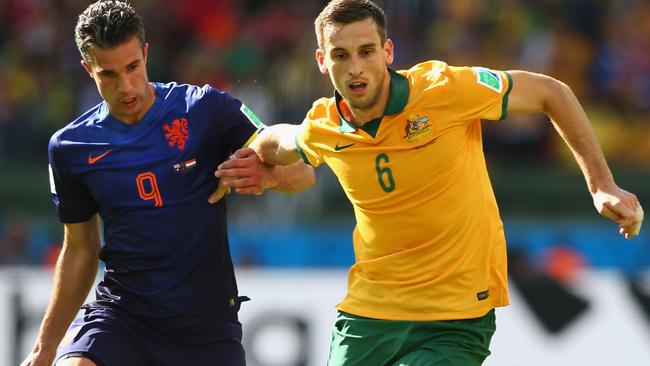 PORTO ALEGRE, BRAZIL - JUNE 18: Robin van Persie of the Netherlands and Matthew Spiranovic of Australia compete for the ball during the 2014 FIFA World Cup Brazil Group B match between Australia and Netherlands at Estadio Beira-Rio on June 18, 2014 in Porto Alegre, Brazil. (Photo by Quinn Rooney/Getty Images)