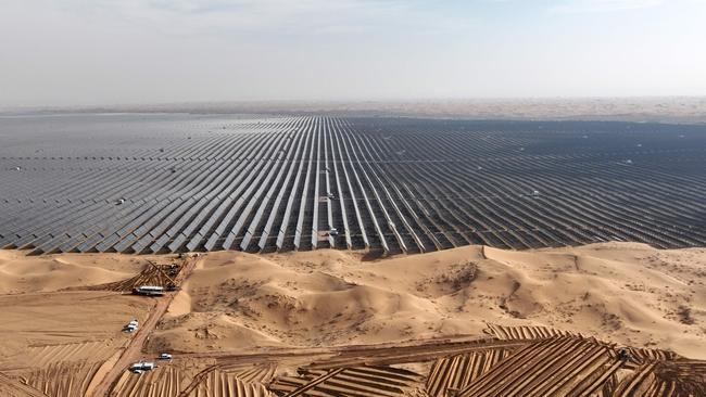 Vehicles prepare the ground for new solar panels next to a field of solar panels during construction at the Ningxia Tengger Desert New Energy Base in China’s northern Ningxia region. (Photo by AFP) / China OUT