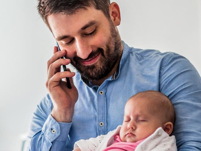 CAREERS: Businessman multi-tasks while holding his daughter and working from home