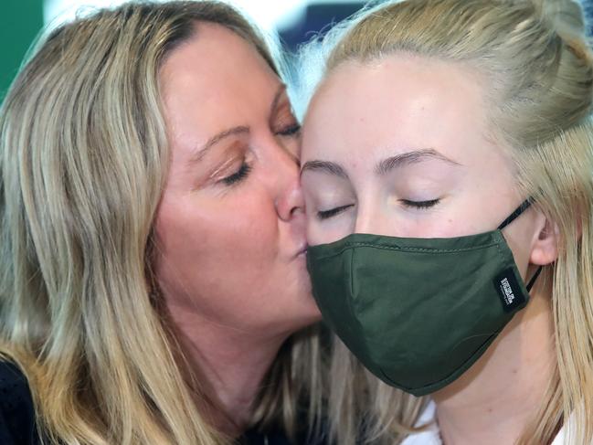 BRISBANE, AUSTRALIA - DECEMBER 01: Helen Baxter greets her daughter Holly, after Holly arrived on the first flight from Melbourne since the Queensland border re-opened, on December 01, 2020 in Brisbane, Australia. Queensland has eased its COVID-19 border restrictions, with travellers from New South Wales and Victoria now permitted to enter the state without having to quarantine.  (Photo by Jono Searle/Getty Images)