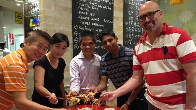 Staff and guests toss a traditional new year’s dish at Wok Passion.