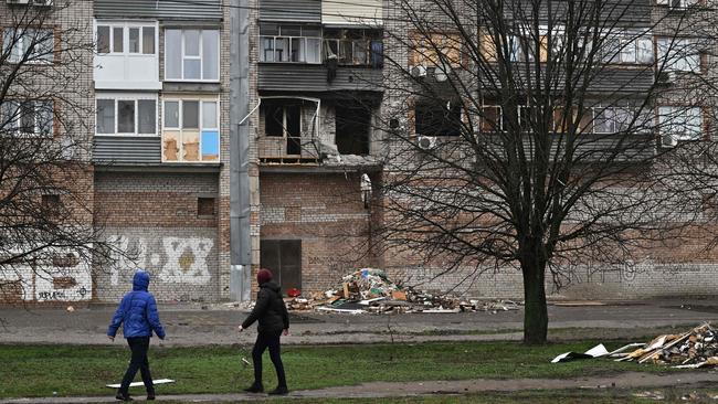 Local residents walk past a damaged building following Russian attacks in the southern city of Nikopol. Picture: AFP