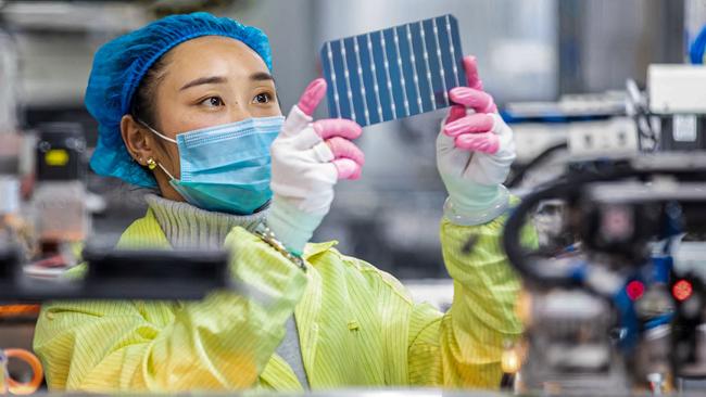 A worker checks solar photovoltaic modules used for small solar panels at a factory in Haian. China, the heaviest carbon emitter by some way, is on track to become the world’s only green energy superpower. Picture: AFP