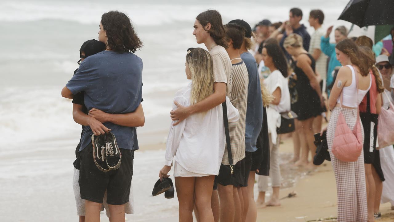 Family and friends of 16-year-old alleged stabbing victim Balin Stewart gather to pay tribute on his home beach at Buddina. Picture: Lachie Millard